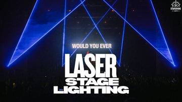 Laser stage lighting beams over festival crowd at night